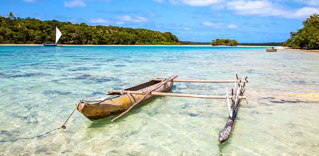 A traditional outrigger canoe floating on a lagoon in the Isle of Pines.