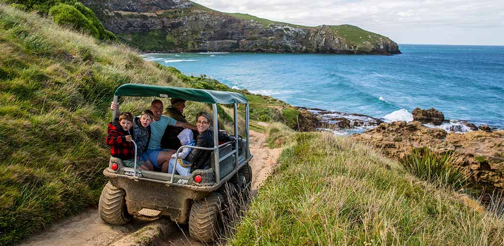 A family on tour od Dunedin's coastline in New Zealand