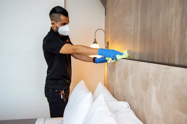 The Hilton's housecleaning members wiping down high-touch areas before and after guests' stays.