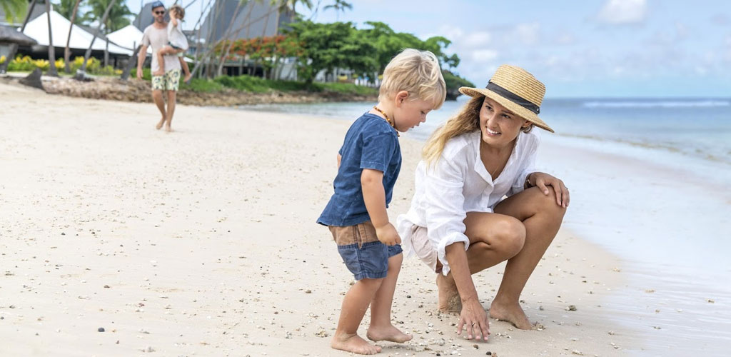 A woman playing with her child on a beach in Fiji