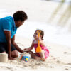 A nanny playing with a kid on a beach in Fiji.