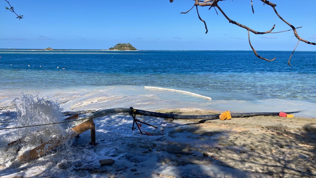 A view of the beach at Malolo Island Resort, the blue seas beyond at an island in the distance.